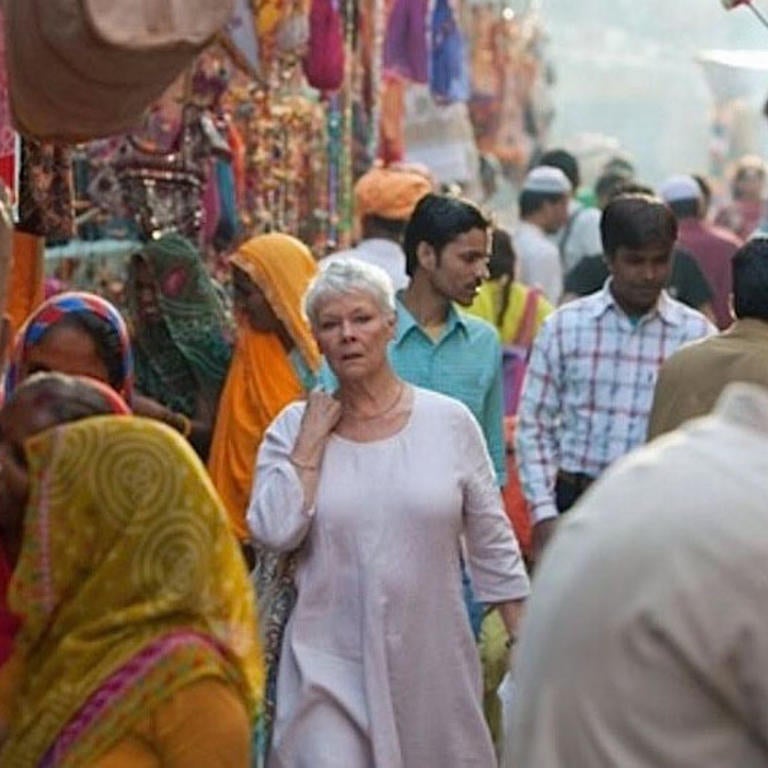 A lovely older woman walking through a crowded street in India 