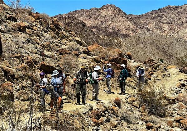 Community scientists on a trail near a mountain