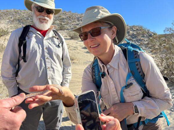 Two naturalists looking at a snake in someone's hand