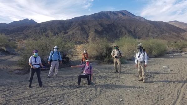 Cool scientists standing on a trail, masked 