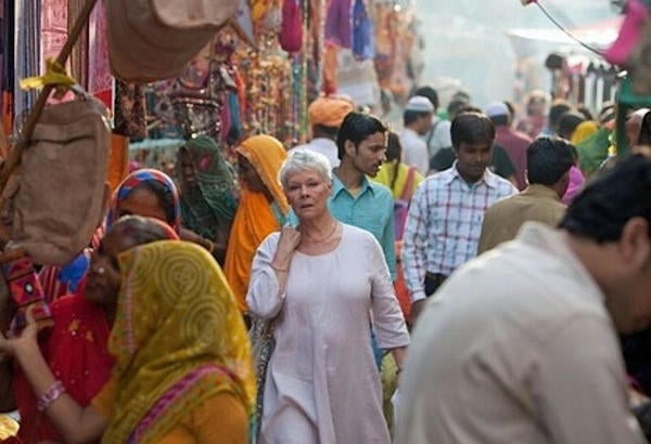 A lovely older woman walking through a crowded street in India 