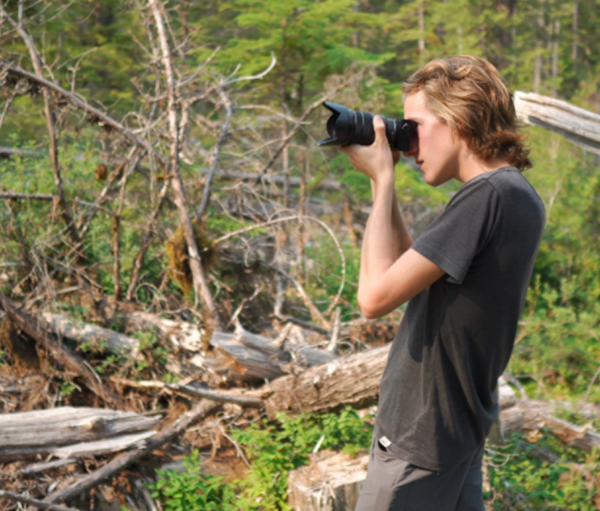 Filmmaker Joshua Wright stands with a camera